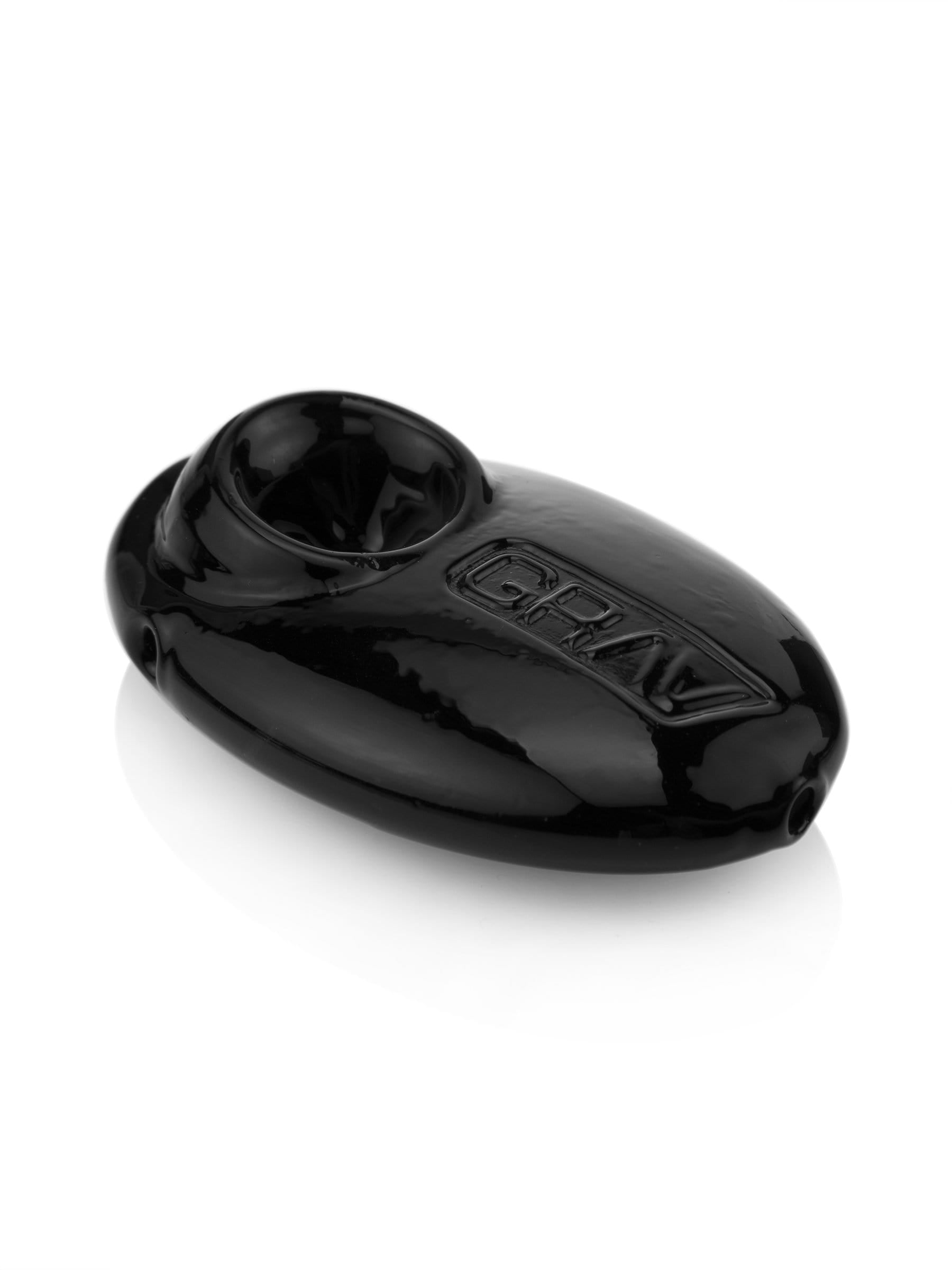 A three-quarter view of the Pebble Spoon Pipe, showcasing its smooth, dark glass construction against a bright, neutral background.