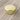 A top-down view of the Aluminium Storage Puck, a small, silver disc resting on a textured wooden surface.