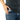 A close-up, side view shows the Aluminium Storage Puck held in a person’s hand against dark denim.
