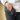 A hand holds the black ONGROK Smell Proof Wrist Bag, viewed from a slightly angled front perspective.