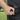 A close-up, angled view shows the Premium Storage Tube held between fingers against a dark textured background.