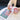 A hand holds the 5 Piece Storage Grinder against a blurred background with colorful text visible on the surface below.